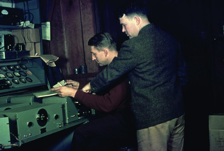 Dave Packard and Bill Hewlett working at a workbench.