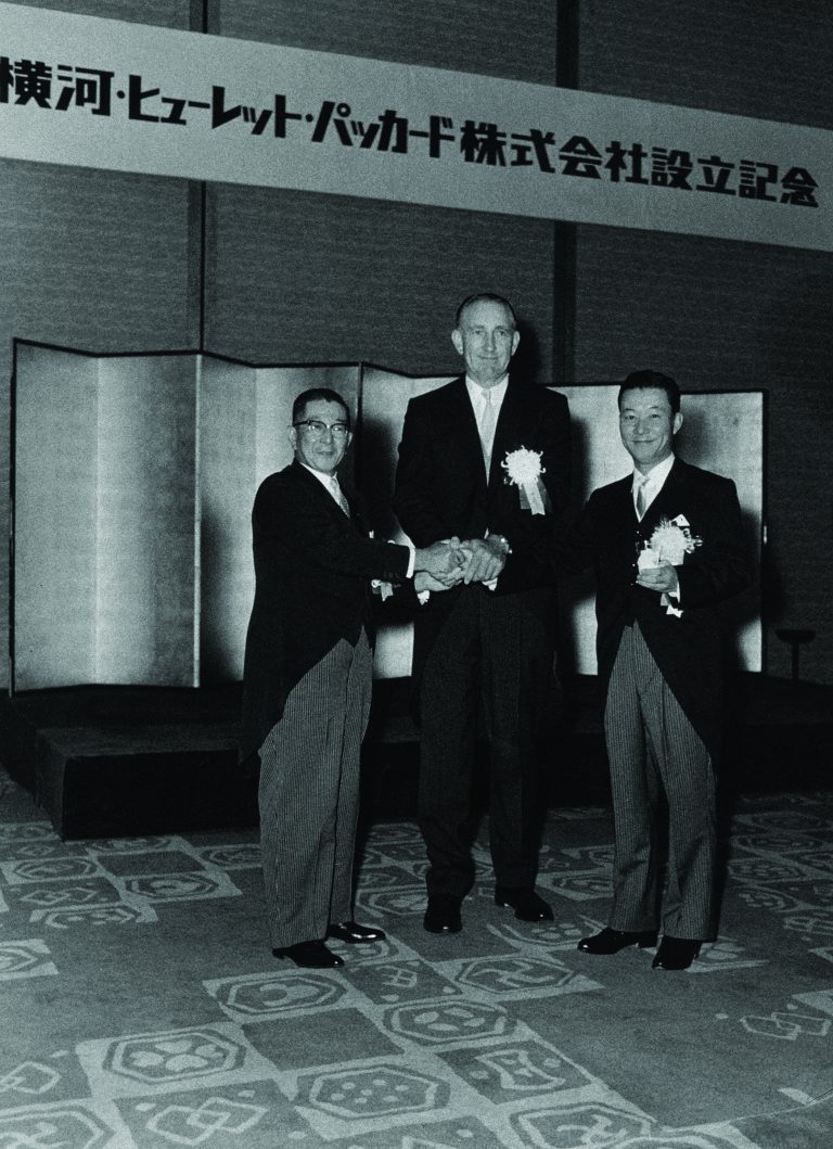 Dave Packard shaking hands with two men at the launch of Yokogawa Hewlett-Packard in 1963.