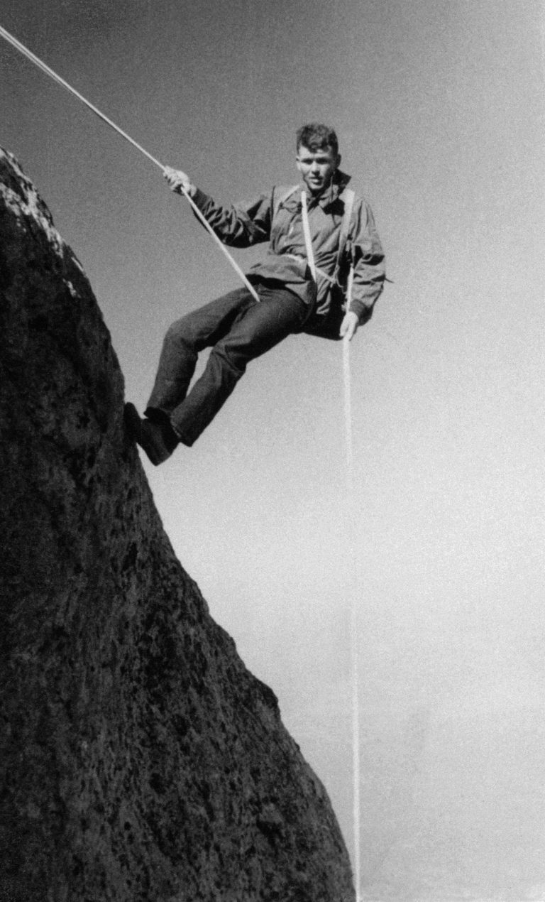 Bill Hewlett rappelling down the side of a mountain.