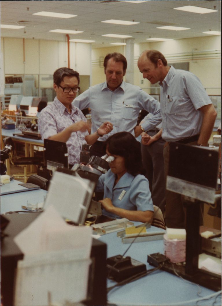 John Young spending time with employees at a Hewlett-Packard plant in Malaysia in the 1980s.