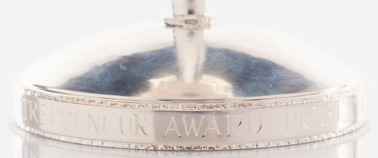 Partial view of the bottom of the Computer Entrepreneur Award. Reads Trepreneur Award Presen.