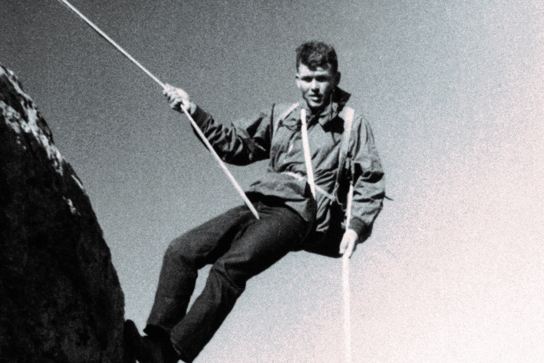 Bill Hewlett rappelling down the side of a mountain.