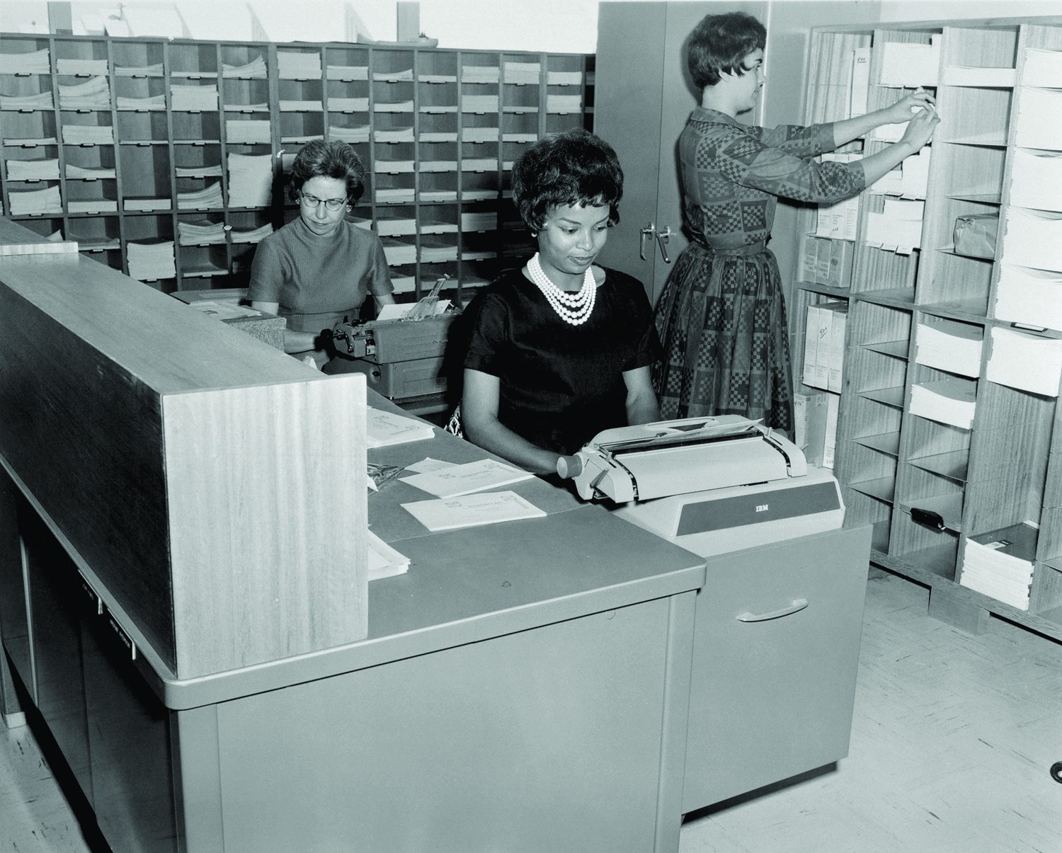 A photo of three women working in an office performing marketing and public relations duties.