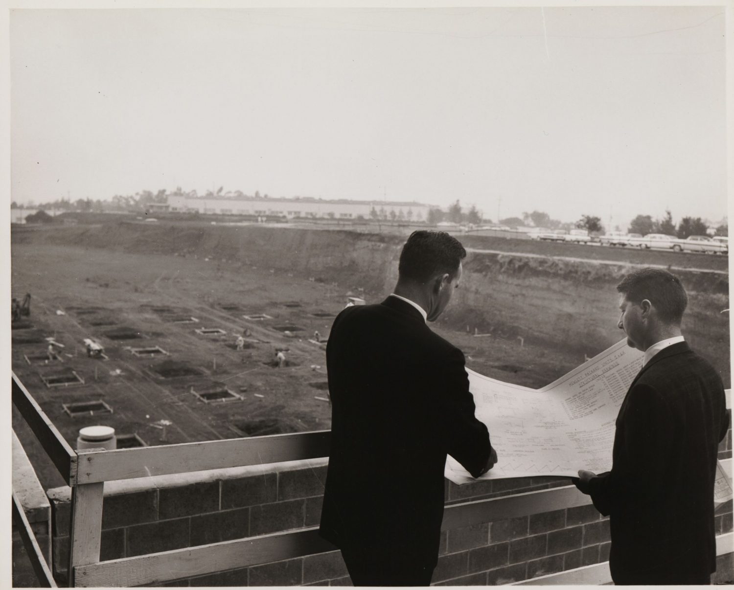 Two men review plans at the new HP site at Stanford Industrial Park in 1957, the site of HP's future headquarters campus.