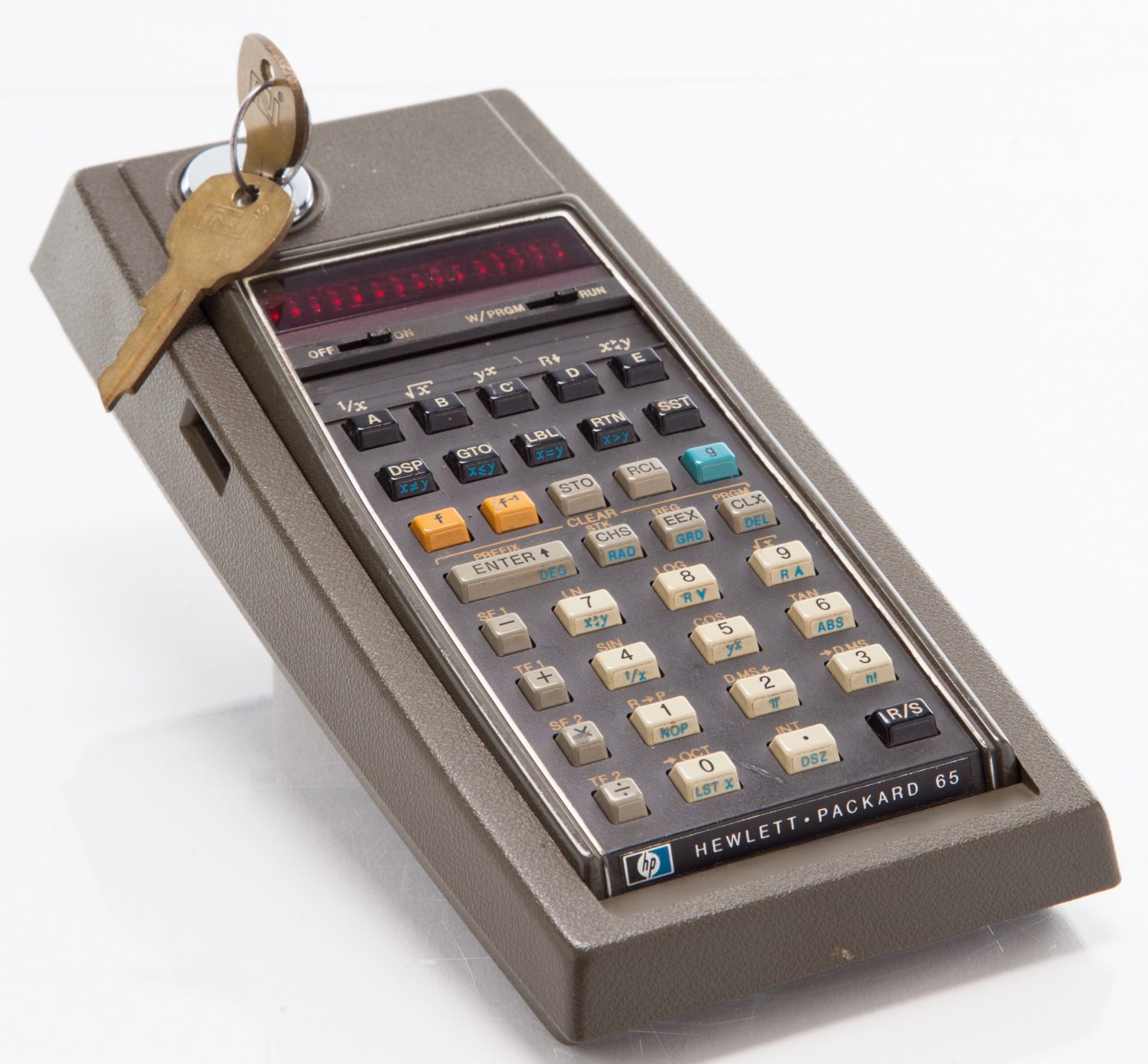 Photo of the HP 65 calculator in its locking cradle with key in the lock.
