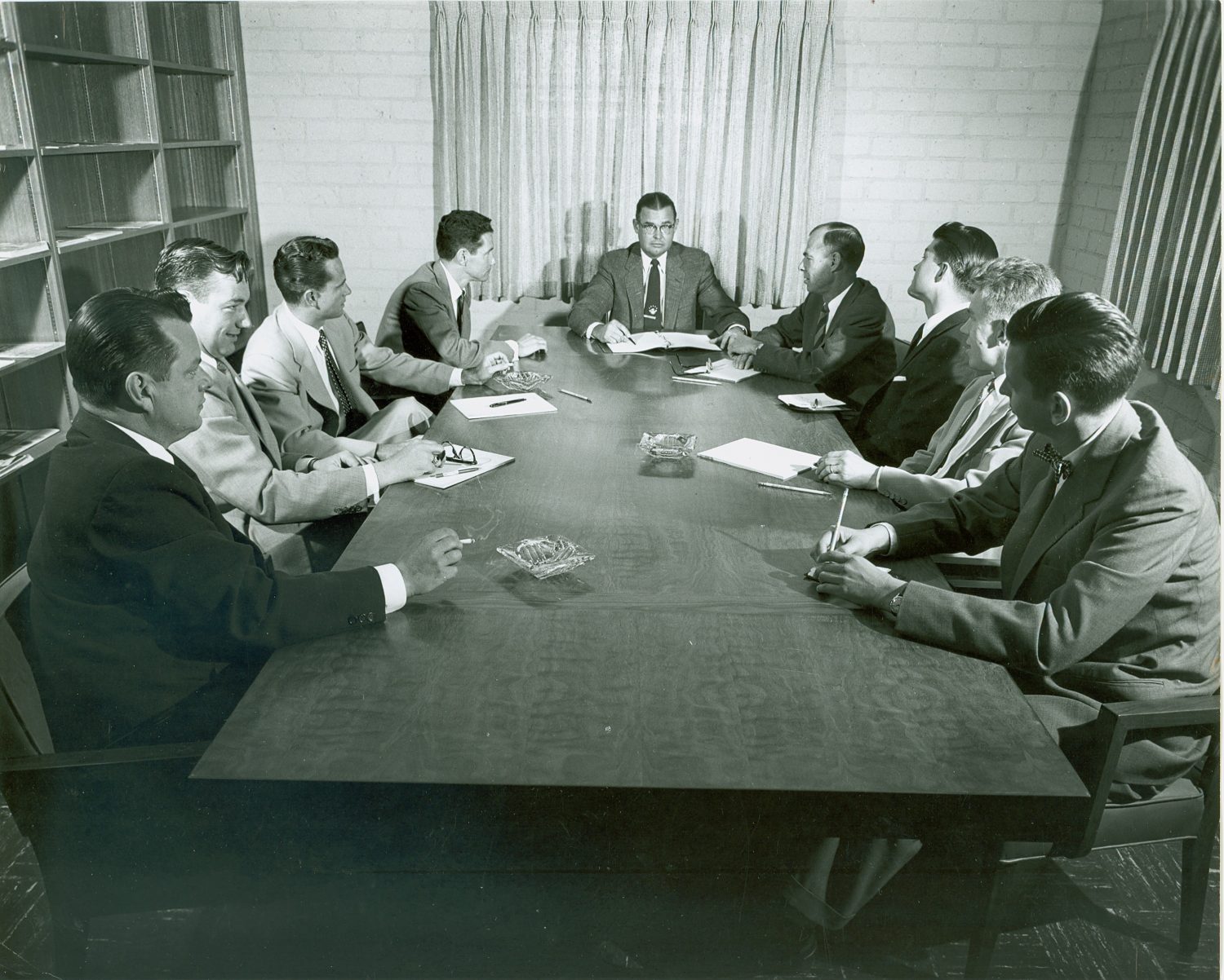 Norm Neely and his sales team seated around a conference table in 1954.