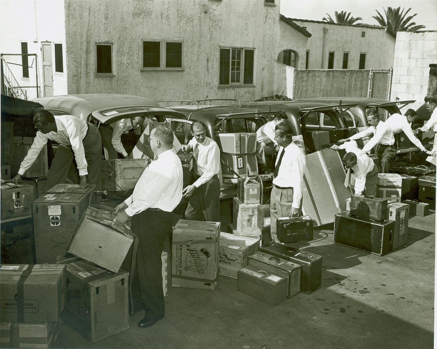 Salesmen placing Hewlett-Packard equipment in vehicles to prepare for road shows in 1952.