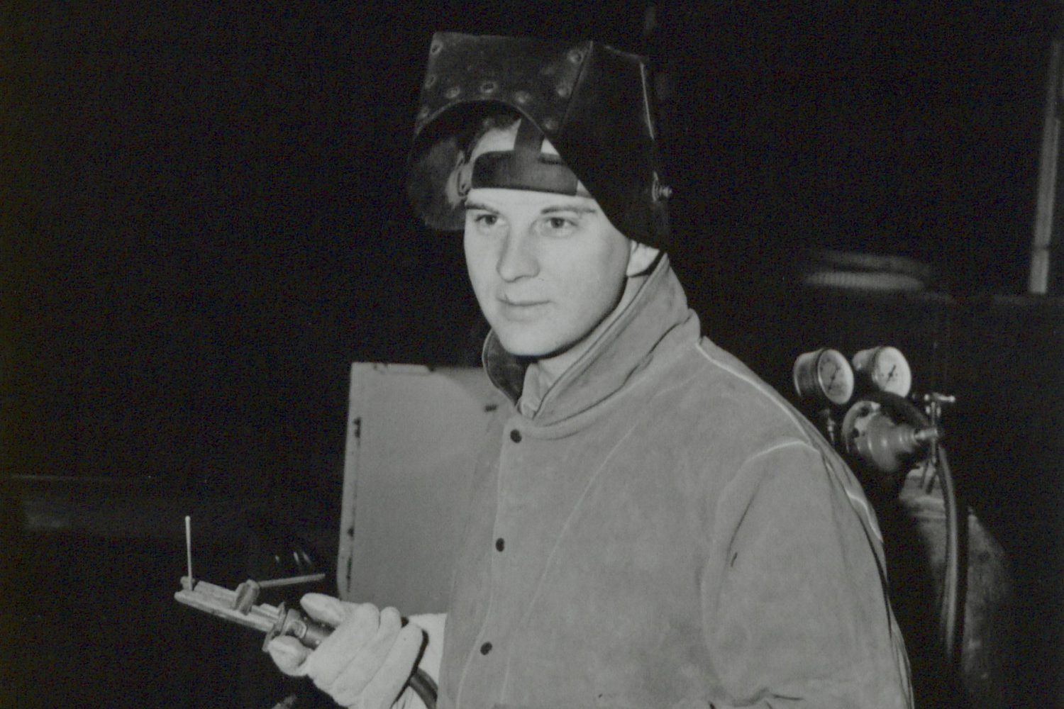 Photo of Harvey Zieber, Hewlett-Packard's first employee, with a welding helmet and blow torch.