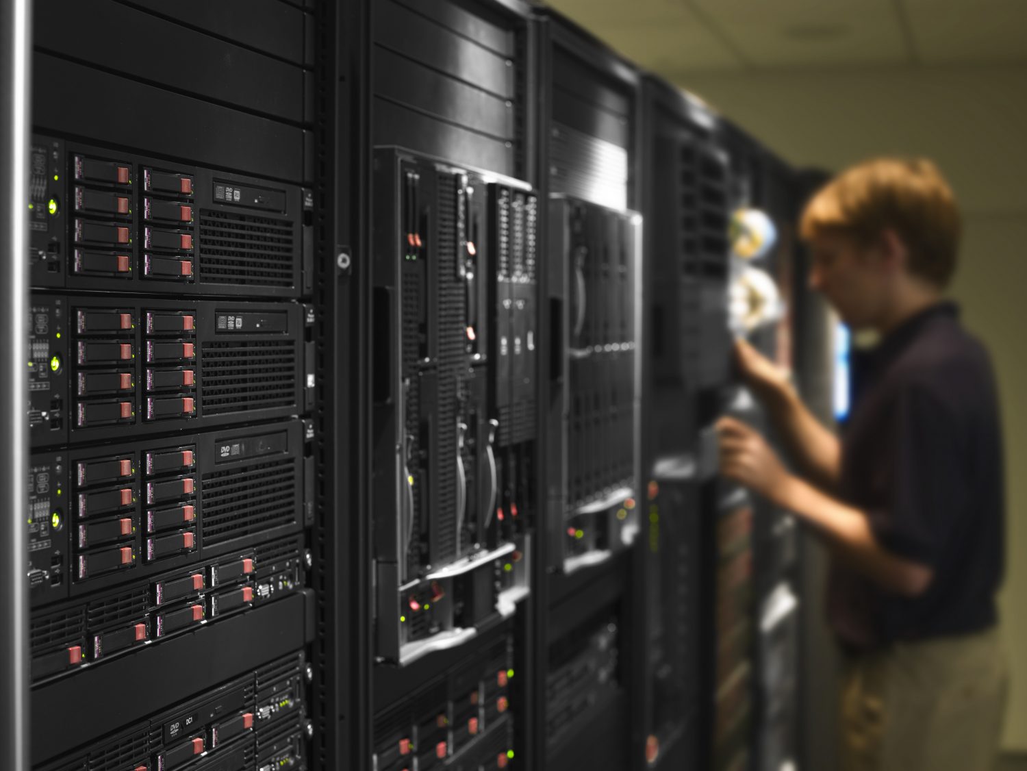 Photo of ProLiant servers with a technician working on them in the background.