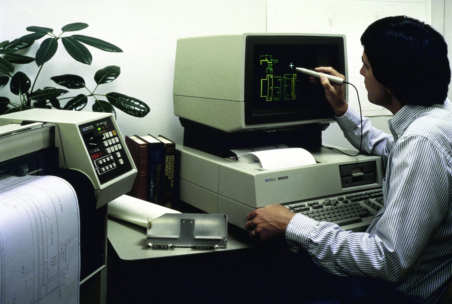 A man works with a stylus on the HP 520/9000 desktop computer.