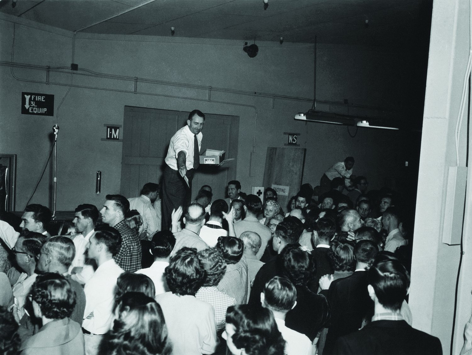 Dave Packard handing out profit-sharing bonuses to a crowd of HP employees in 1954.