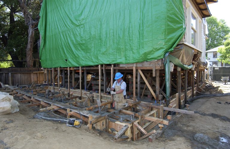 Workers pouring a new concrete and rebar foundation for the Addison Avenue house.