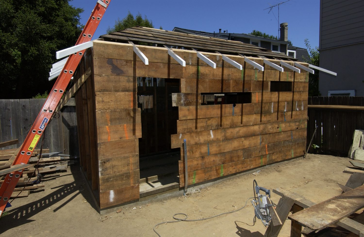 Photo of wood reclaimed from the Addison Avenue house to replace damaged boards on Hewlett's shed during the restoration.