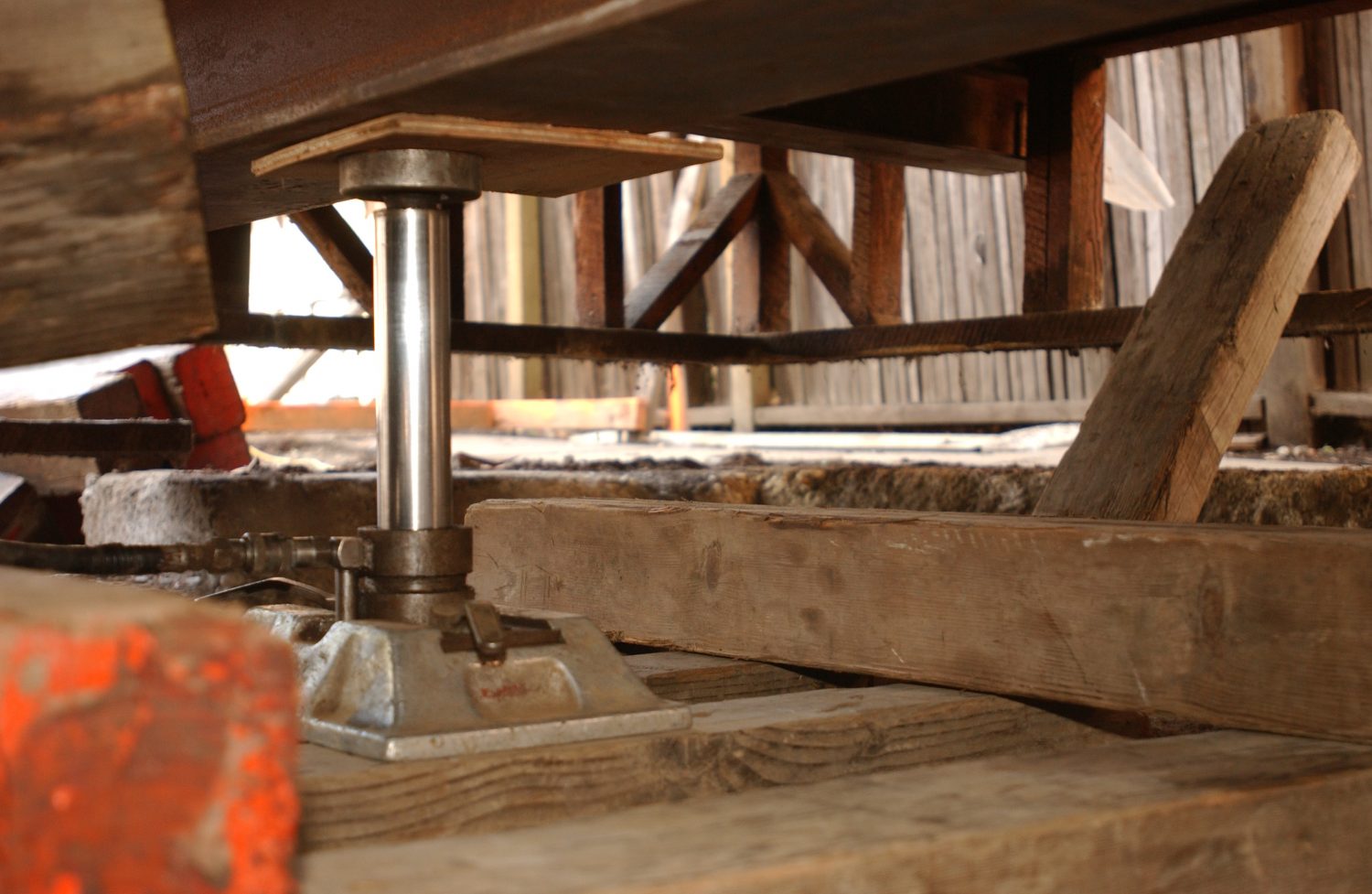 A heavy-duty hydraulic jack lifts a section of the Addison Avenue house during the restoration project.