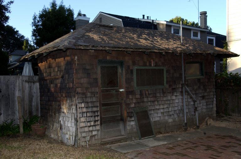 A photo of Bill Hewlett's shed before the restoration process with a hole in the roof and obvious signs of wear throughout.