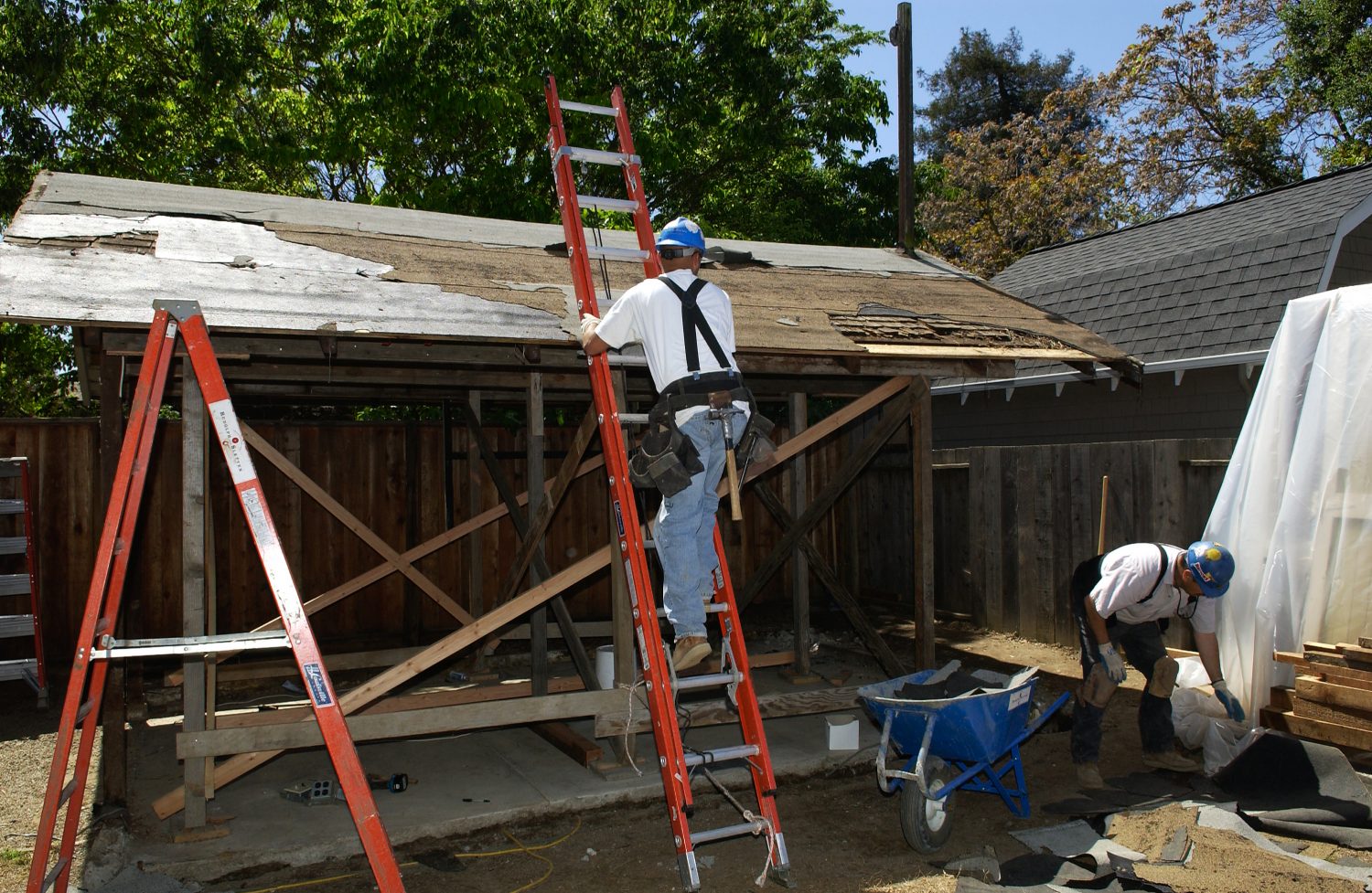 A worker on a ladder working on the garage renovation at Addison Avenue.