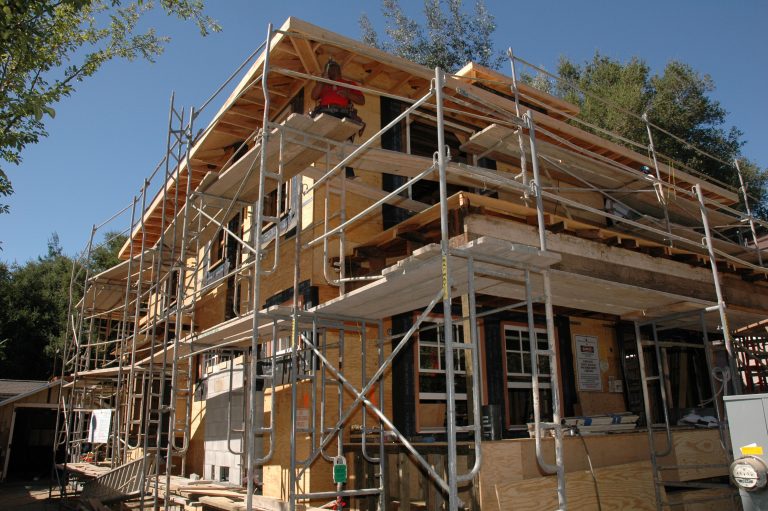 A photo of the Addison Avenue house wrapped in scaffolding during the renovation.