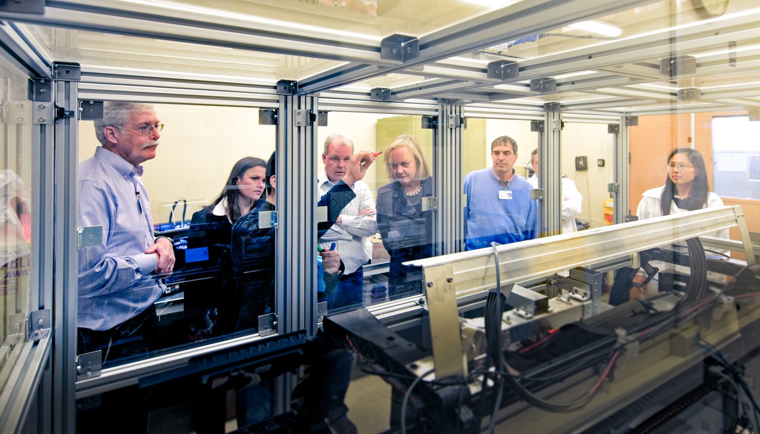 Meg Whitman watches as the printing team of HP Labs demonstrates its 3D printing testbed for her.
