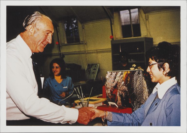 Dave Packard chatting and shaking hands with a female employee at HP.