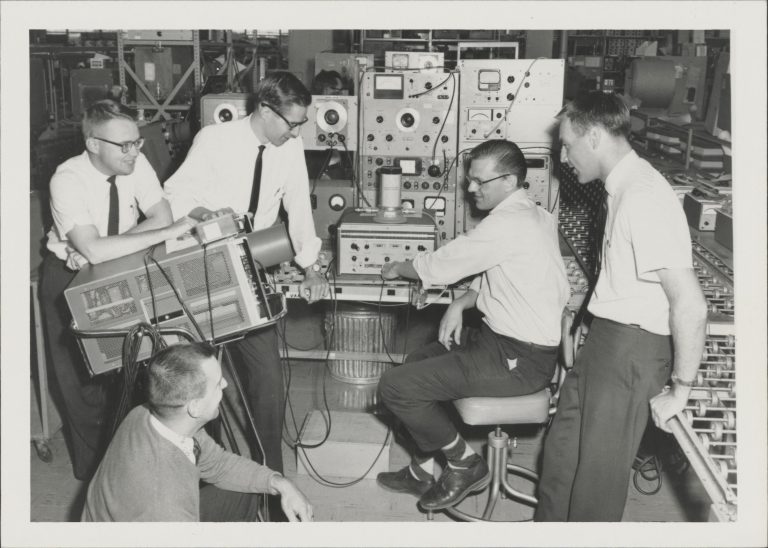 Several HP engineers, including future CEO John Young (far right) watching a microwave product test.