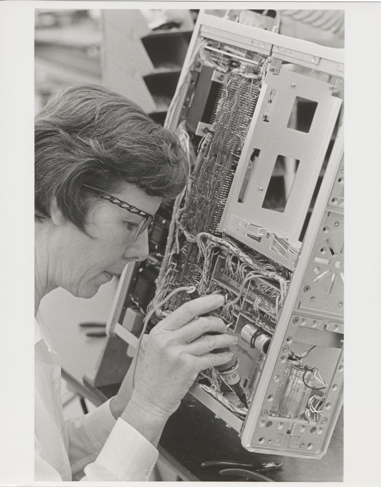 A woman soldering a component for the HP 5360A computer counter.
