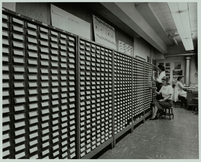 Three women working the name bank card catalog. 