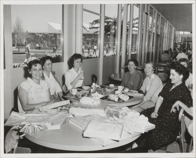 Photo of six women gathered around a table during a baby shower in the 1960s.