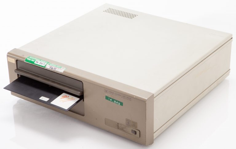 Photo of the HP 9855M floppy disk drive with an 8-inch disk partially in the drive.