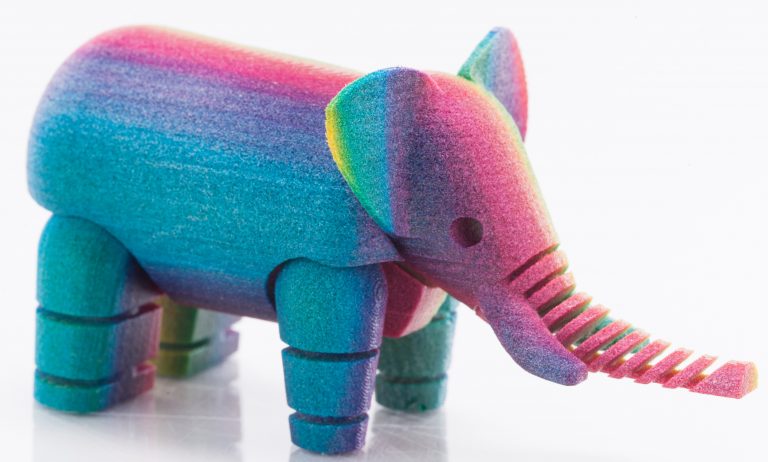 A 3D-printed elephant with various colors from blue and purple to pink.