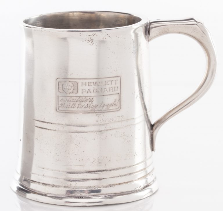 A pewter mug featuring the HP logo and the phrase Calculators: Built to Stay Tough.