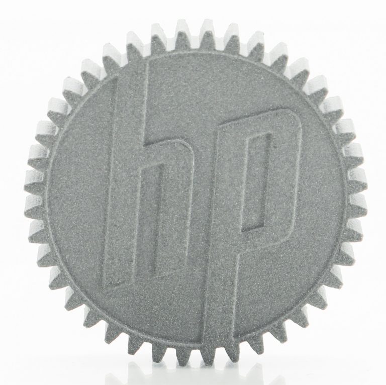 The HP logo embossed on a 3D-printed plastic gear.