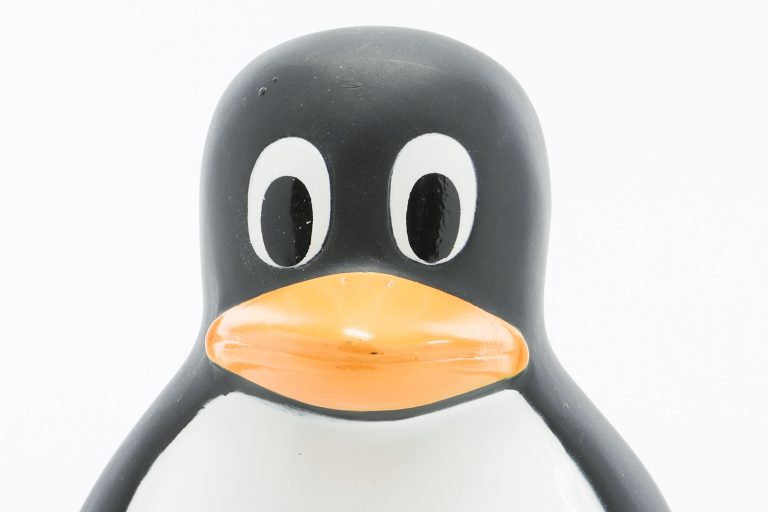 A Linux penguin toy featuring the HP Invent logo on its belly.