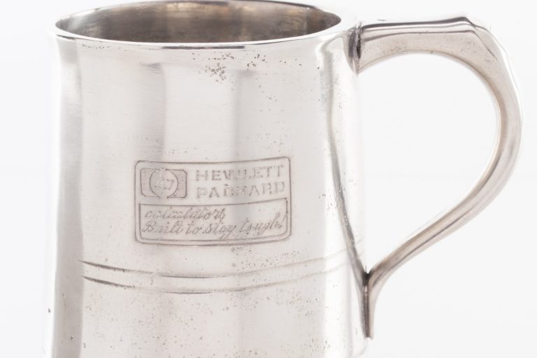 A pewter mug featuring the HP logo and the phrase calculators Built to stay tough.