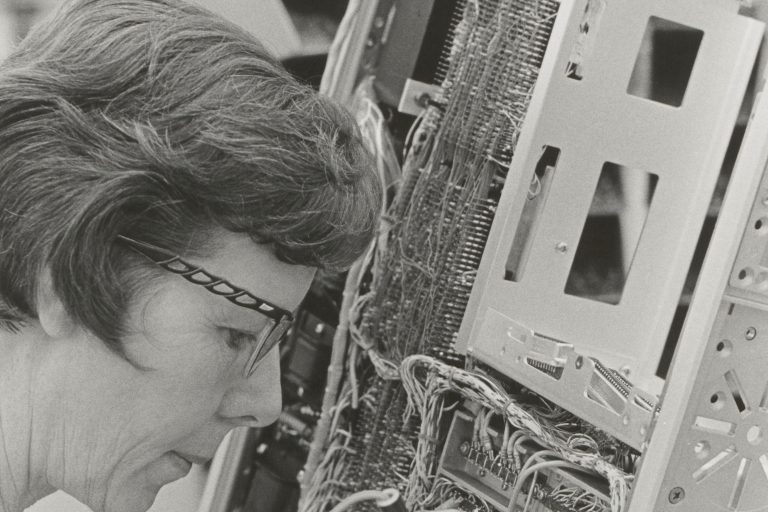 A woman soldering a component for the HP 5360A computer counter.