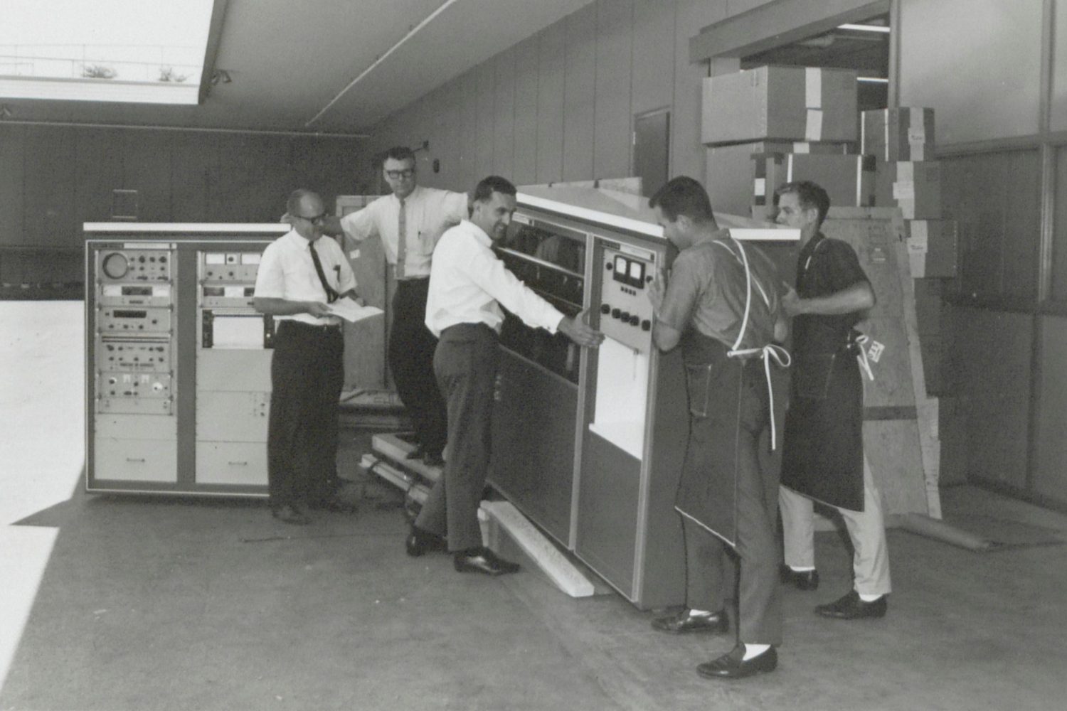 Employees moving the HP 8400A microwave spectrometer in 1964.