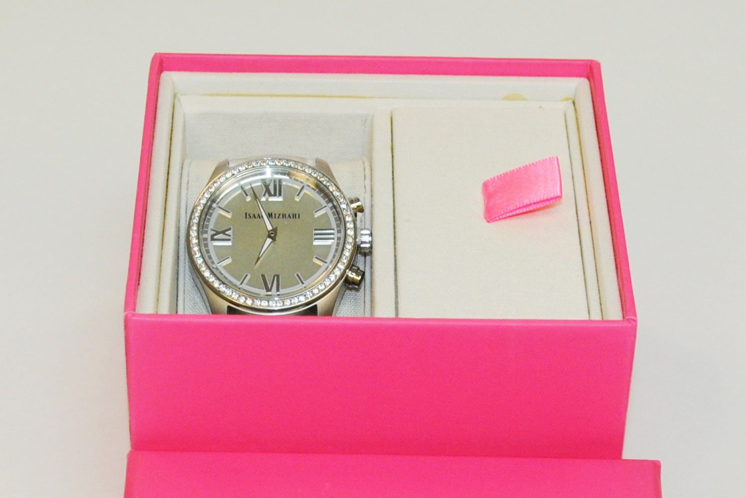 Photo of Isaac Mizrahi smartwatch featuring HP technology and Swarovski crystals in a pink display box.