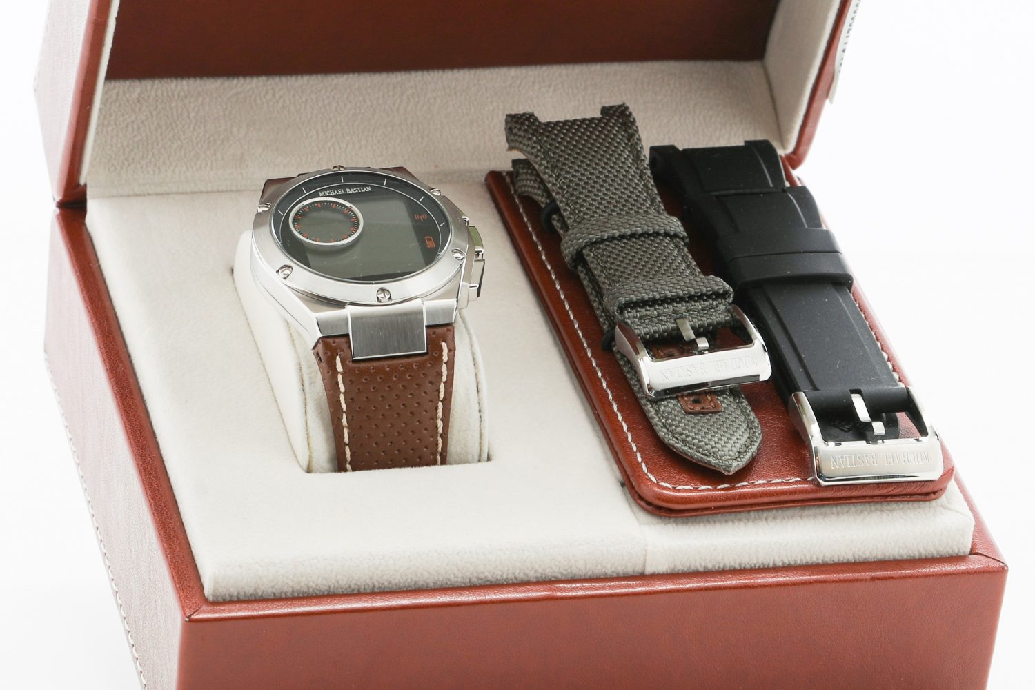 The Michael Bastian smartwatch in its box (opened) with additional strap options.