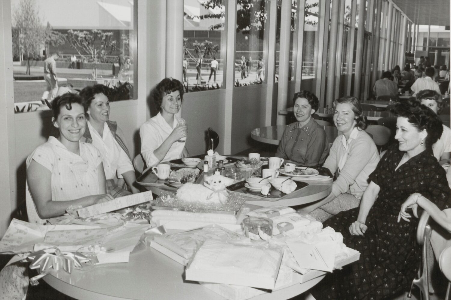 Photo of six women gathered around a table during a baby shower in the 1960s.
