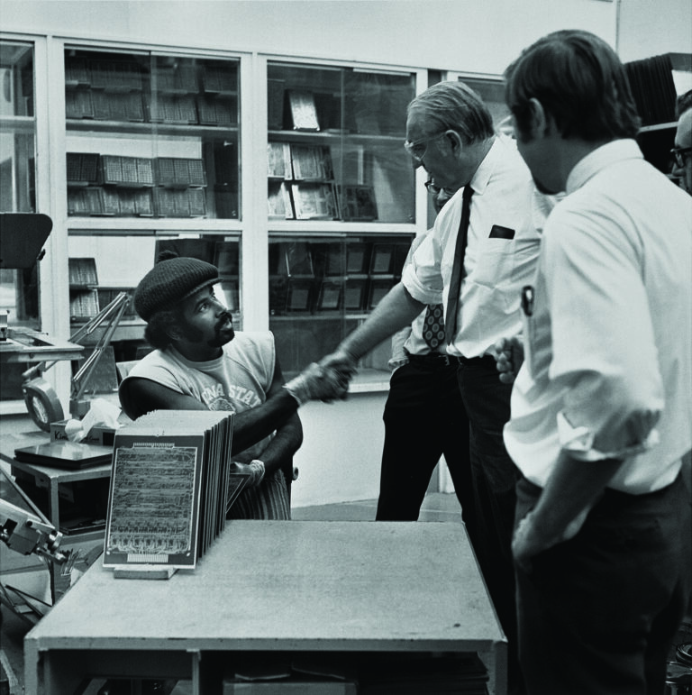 Photo of Dave Packard speaking with an employee in 1974.