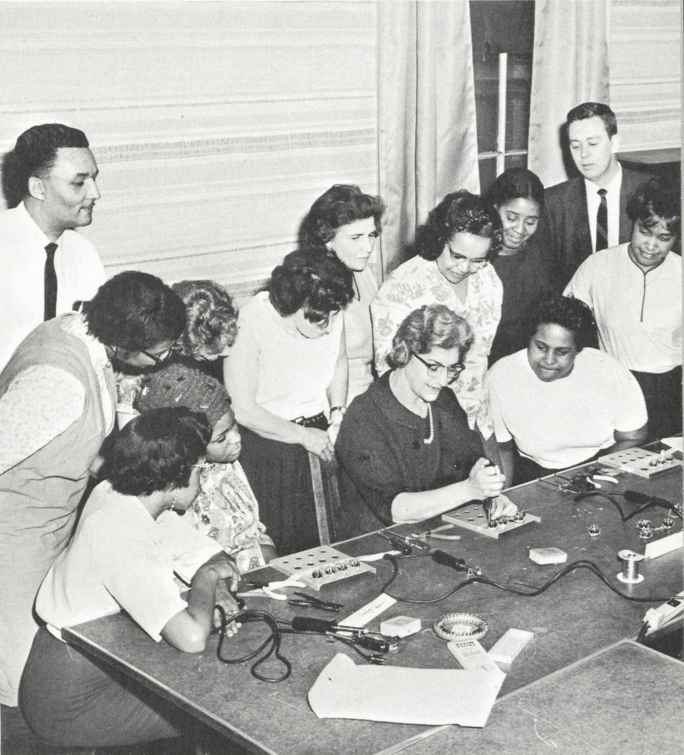 Sanborn plant employees teaching assembly techniques to a group of women at the Cambridge Community Center.