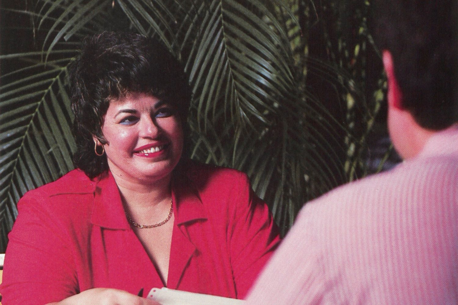 Mabel Esteves seated at a desk opposite a male colleague in 1988.